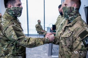 Braterski uścisk dłoni dwóch funkcjonariuszy WZD NwOSG 10 lat WZD NwOSG