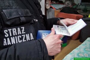 Funkcjonariusz SG trzymający paszport Funkcjonariusz SG trzymający paszport