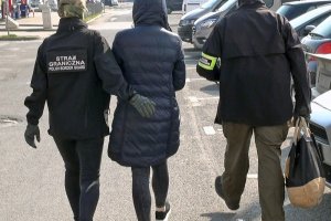 Funkcjonariusze SG prowadzą zatrzymaną do samochodu Funkcjonariusze SG prowadzą zatrzymaną do samochodu