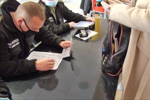 Funkcjonariusz SG sprawdzający paszport Funkcjonariusz SG sprawdzający paszport