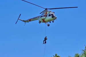 Funkcjonariusz wiszący na linie pod śmigłowcem Funkcjonariusz wiszący na linie pod śmigłowcem