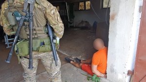 Funkcjonariusz grupy realizacji pilnuje zatrzymanego. Funkcjonariusz grupy realizacji pilnuje zatrzymanego.