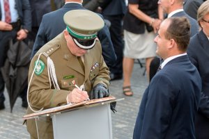 Płk SG Dariusz Lutyński dokonuje wpisu do księgi pamiątkowej. Płk SG Dariusz Lutyński dokonuje wpisu do księgi pamiątkowej.