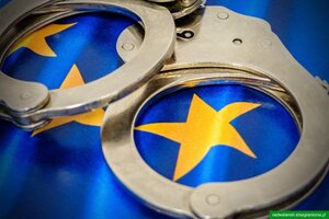 Flaga EU z kajdankami Flaga Unii Europejskiej, na której leżą kajdanki
