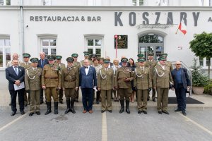 Zdjęcie pamiątkowe uczestników uroczystości na tle tablicy. Zdjęcie pamiątkowe uczestników uroczystości na tle tablicy.