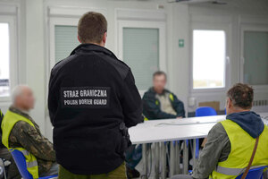 Funkcjonariusz SG stojący przed pracownikami budowlanymi./archiwum NwOSG. Funkcjonariusz SG stojący przed pracownikami budowlanymi./archiwum NwOSG.