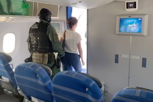 Kobieta wyprowadzana z samolotu przez funkcjonariusza Straży Granicznej. Kobieta wyprowadzana z samolotu przez funkcjonariusza Straży Granicznej.