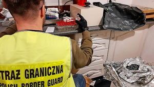 Funkcjonariusz SG trzyma w ręku fiolę. Funkcjonariusz SG trzyma w ręku fiolę.