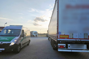 Na parkingu stoi samochód Straży Granicznej i dwie ciężarówki. Na parkingu stoi samochód Straży Granicznej i dwie ciężarówki.