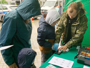 Technik kryminalistyki pobiera odciski palców od chłopca. Technik kryminalistyki pobiera odciski palców od chłopca.