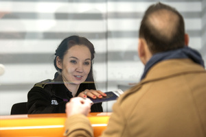 Funkcjonariuszka podaje paszport podróżnemu. Funkcjonariuszka podaje paszport podróżnemu.