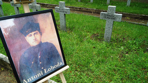Fotografia Antoniego Łobody stoi na sztaludze przy mogile. Fotografia Antoniego Łobody stoi na sztaludze przy mogile.
