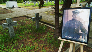 Fotografia Stefana Galińskiego stoi na sztaludze przy mogile. Fotografia Stefana Galińskiego stoi na sztaludze przy mogile.