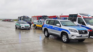 Na płycie lotniska stoją pojazdy służb. Na płycie lotniska stoją pojazdy służb.