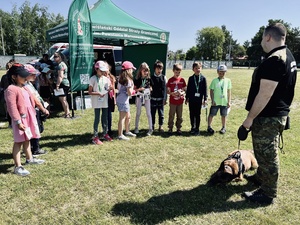 Zgromadzone dzieci soją na przeciwko psa służbowego i jego przewodnika. Zgromadzone dzieci soją na przeciwko psa służbowego i jego przewodnika.