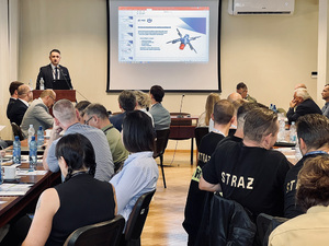 Uczestnicy konferencji siedzą przy stołach, słuchają prelegenta. Uczestnicy konferencji siedzą przy stołach, słuchają prelegenta.