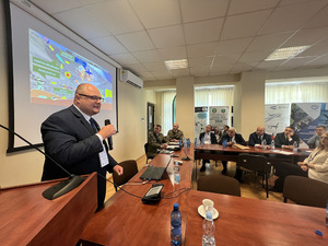 Uczestnicy konferencji siedzący przy stołach słuchają prelegenta. Uczestnicy konferencji siedzący przy stołach słuchają prelegenta.