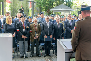 Stoją kombatanci, przedstawiciele władz i urzędów państwowych, zaproszeni goście oraz pracownicy Polskiej Wytwórni Papierów Wartościowych. Stoją kombatanci, przedstawiciele władz i urzędów państwowych, zaproszeni goście oraz pracownicy Polskiej Wytwórni Papierów Wartościowych.
