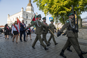 Maszeruje Poczet Sztandarowy Nadwiślańskiego Oddziału Straży Granicznej. Na drugim planie Poczty Sztandarowe oraz budynek Urzędu Miejskiego. Maszeruje Poczet Sztandarowy Nadwiślańskiego Oddziału Straży Granicznej. Na drugim planie Poczty Sztandarowe oraz budynek Urzędu Miejskiego.