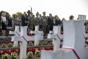 Na cmentarzu stoi Komendant NwOSG wraz z delegacją, władze Szydłowca, przedstawiciele szkół i instytucji, mieszkańcy. Na pierwszym planie widoczne białe krzyże. Na cmentarzu stoi Komendant NwOSG wraz z delegacją, władze Szydłowca, przedstawiciele szkół i instytucji, mieszkańcy. Na pierwszym planie widoczne białe krzyże.
