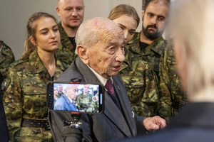 Pan Jerzy Mindziukiewicz w otoczeniu funkcjonariuszy. U dołu widać nagrywający zdarzenie telefon. Pan Jerzy Mindziukiewicz w otoczeniu funkcjonariuszy. U dołu widać nagrywający zdarzenie telefon.