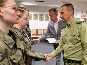 Komendant Placówki ściska dłoń kadeta. Na drugim planie Dyrektor Szkoły wręcza Akt Mianowania. Komendant Placówki ściska dłoń kadeta. Na drugim planie Dyrektor Szkoły wręcza Akt Mianowania.