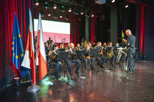 Muzycy siedzą na krzesłach i dają koncert. Muzycy siedzą na krzesłach i dają koncert.