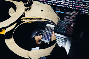 Grafika przedstawia połączenie obrazów kajdanek, laptopa i telefonu komórkowego. Grafika przedstawia połączenie obrazów kajdanek, laptopa i telefonu komórkowego.