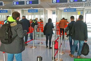 Podróżni stoją przed kabinami kontrolerskimi. Czekają na odprawę graniczną. Podróżni stoją przed kabinami kontrolerskimi. Czekają na odprawę graniczną.