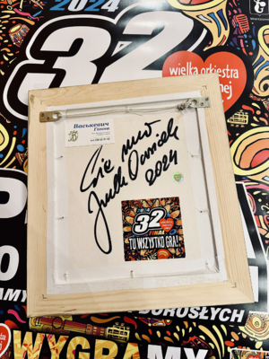 Rewers ramki z logo SG z autografem Jurka Owsiaka 