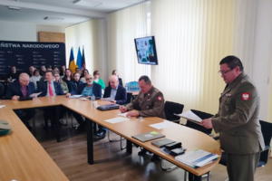 Uczestnicy sympozjum siedzą przy stołach. Uczestnicy sympozjum siedzą przy stołach.