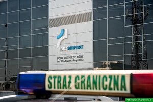 Kogut na dachu samochodu służbowego. W głębi terminal lotniska w Łodzi. Kogut na dachu samochodu służbowego. W głębi terminal lotniska w Łodzi.