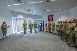Uczestnicy spotkania stoją w sali podczas odczytywania rozkazów. Uczestnicy spotkania stoją w sali podczas odczytywania rozkazów.
