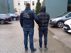 Funkcjonariusz prowadzi zatrzymanego. Funkcjonariusz prowadzi zatrzymanego.