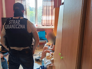 Funkcjonariusz pilnuje zatrzymanego w pomieszczeniu. Funkcjonariusz pilnuje zatrzymanego w pomieszczeniu.