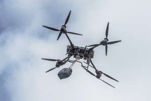 Duży dron z podwieszonym ładunkiem. Duży dron z podwieszonym ładunkiem.