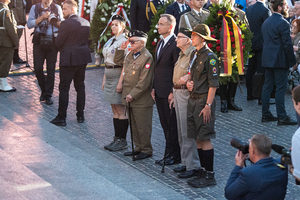 Prezydent z Powstańcami oraz harcerzami stoi przed Pomnikiem Powstania Warszawskiego. Prezydent z Powstańcami oraz harcerzami stoi przed Pomnikiem Powstania Warszawskiego.