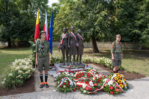 Pomnik Kobietom Powstania Warszawskiego. U stóp leżą wiązanki kwiatów. Asystują harcerze. Pomnik Kobietom Powstania Warszawskiego. U stóp leżą wiązanki kwiatów. Asystują harcerze.