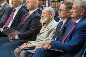 Pan Juliusz Kulesza i goście siedzą na krzesłach. Pan Juliusz Kulesza i goście siedzą na krzesłach.