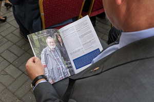 Mężczyzna przegląda okolicznościową publikację, w której widać zdjęcie Pana Juliusza Kuleszy z Karoliną Gorczycą. Mężczyzna przegląda okolicznościową publikację, w której widać zdjęcie Pana Juliusza Kuleszy z Karoliną Gorczycą.