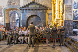 Orkiestra siedzi na ławkach w kościele po prawej stronie stoją soliści. Orkiestra siedzi na ławkach w kościele po prawej stronie stoją soliści.