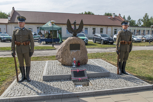 Pomnik żołnierzy KOP z otwartym kolumbarium po bokach stoją funkcjonariusze w historycznych mundurach. Pomnik żołnierzy KOP z otwartym kolumbarium po bokach stoją funkcjonariusze w historycznych mundurach.