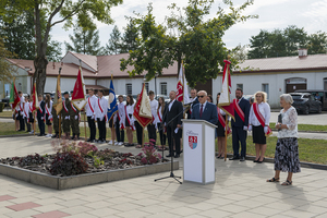 Na tle pocztów sztandarowych przemawia pan Marek Sokołowski. Na tle pocztów sztandarowych przemawia pan Marek Sokołowski.