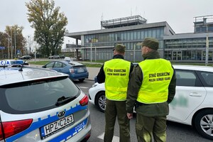 Funkcjonariusze Straży Granicznej stoją przy samochodzie. Funkcjonariusze Straży Granicznej stoją przy samochodzie.