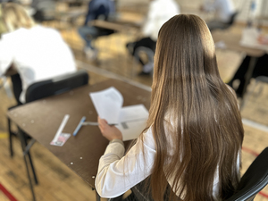 Kandydatka siedzi przy stoliku, przegląda test. Kandydatka siedzi przy stoliku, przegląda test.