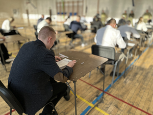 Kandydaci siedzą przy stolikach, rozwiązują testy z wiedzy ogólnej. Kandydaci siedzą przy stolikach, rozwiązują testy z wiedzy ogólnej.