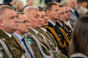 Komendant Nadwiślańskiego Oddziału Straży Granicznej siedzi wśród gości. Komendant Nadwiślańskiego Oddziału Straży Granicznej siedzi wśród gości.