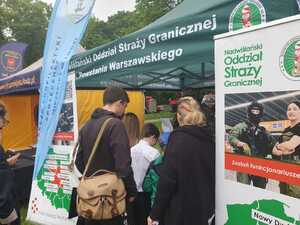 Zwiedzający stoją przed namiotem promocyjnym Straży Granicznej. Zwiedzający stoją przed namiotem promocyjnym Straży Granicznej.