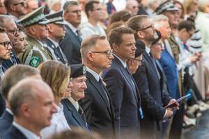 Uczestnicy uroczystości stoją w Parku Wolności. Uczestnicy uroczystości stoją w Parku Wolności.