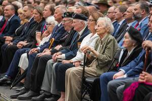 Uczestnicy uroczystości siedzą na krzesłach. Uczestnicy uroczystości siedzą na krzesłach.